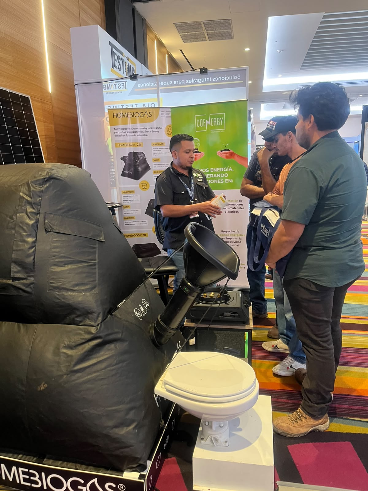 Asesor de COENERGY explicando una solución sostenible a un visitante en CONSTRUEXPO 2026