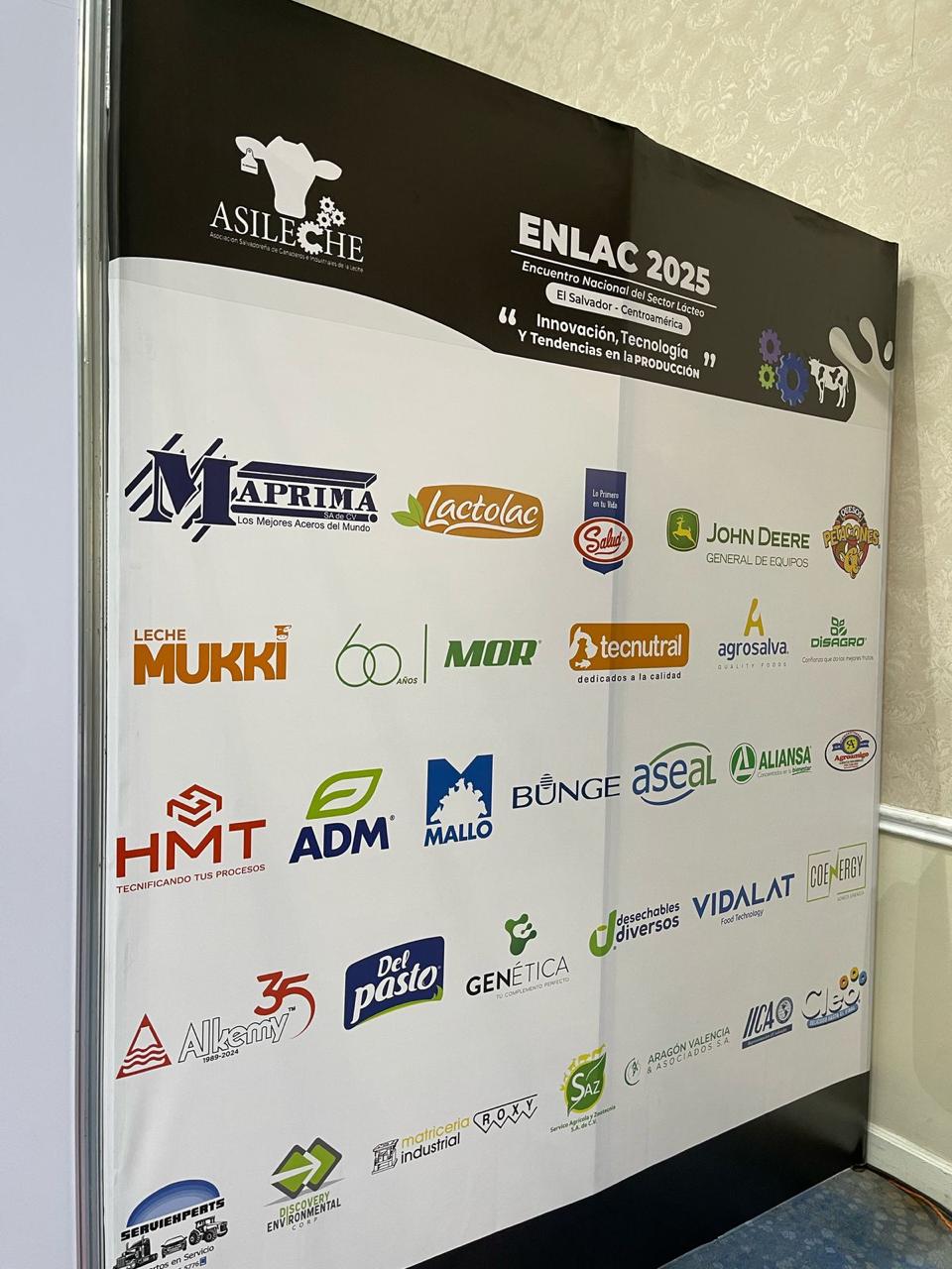 Pared de patrocinadores de ENLAC 2025 con el logo de COENERGY entre las marcas del sector